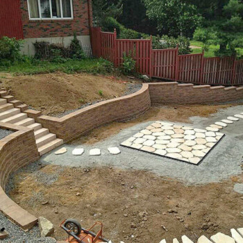 stone steps leading down to stone patio surrounded by block walls