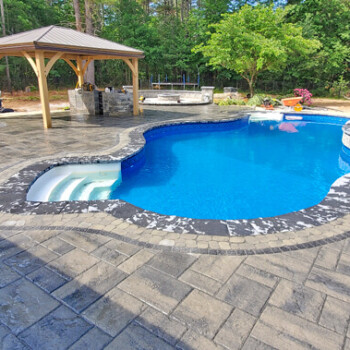 Stone paver patio with covered patio and stone pavers surrounding pool